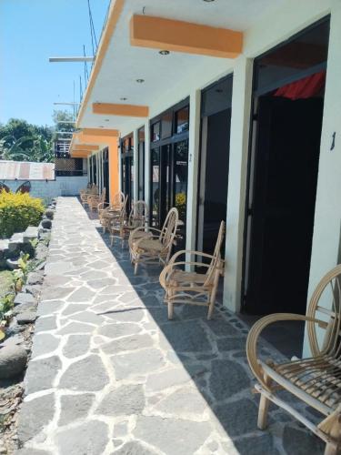 a row of chairs sitting outside of a building at Hotel Porto Bello in San Pedro La Laguna