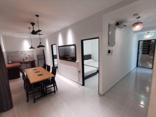 Kulim Mini HomeStay في كوليم: غرفة معيشة مع طاولة وغرفة مع مطبخ