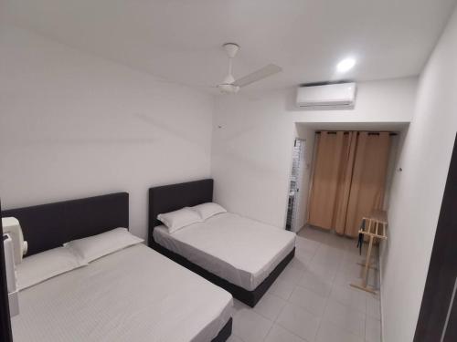 a bedroom with two beds and a door in it at Kulim Mini HomeStay in Kulim