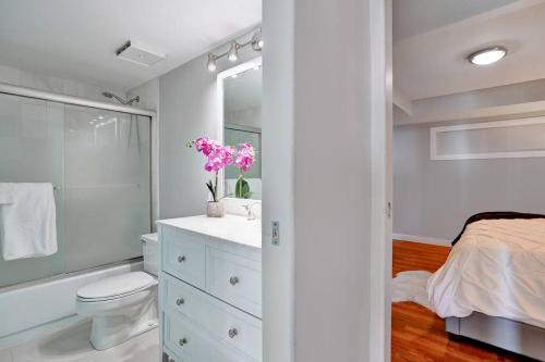 a white bathroom with a toilet and a sink at Sea Forever! Miami Skyline And Water Views in Miami