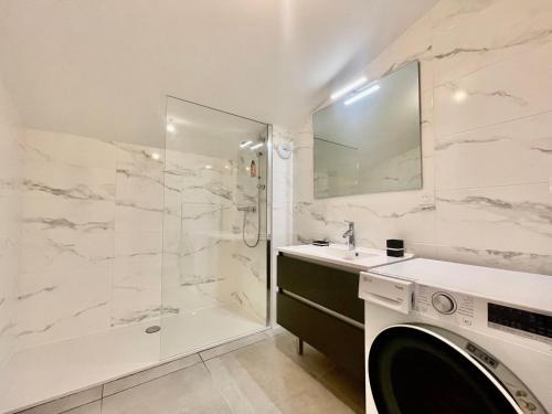 une salle de bain avec douche et machine à laver dans l'établissement Appartement neuf sur les pistes avec parking et wifi - FR-1-505-190, à Notre-Dame-de-Bellecombe