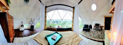 a bedroom with a large bed in a tent at WATERFRONT LUXURY GLAMPING DOME in Rogersville