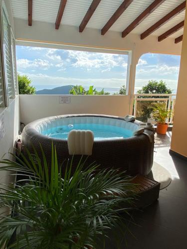 a living room with a hot tub on a patio at Villa NKJ'S in Deshaies