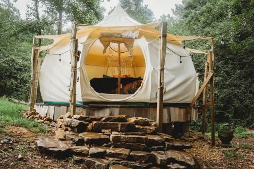 a tent with a pile of logs in front of it at The Pisces-a stargazing, luxury glamping tent in Rogersville