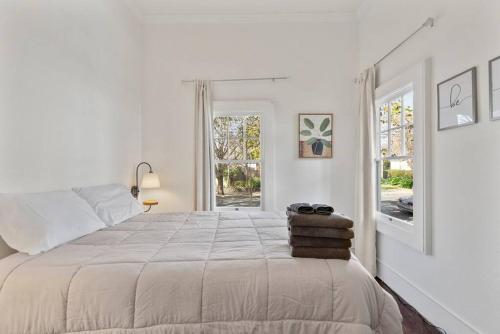 a white bedroom with a large bed and a window at Hot Tub PRIME DWTN NAPA 3 bed 2 Bath in Napa