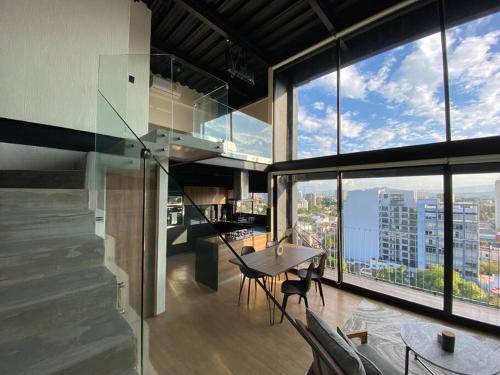 a large room with a table and some windows at Loft Doble Altura Americana Piso 5 @serra in Guadalajara