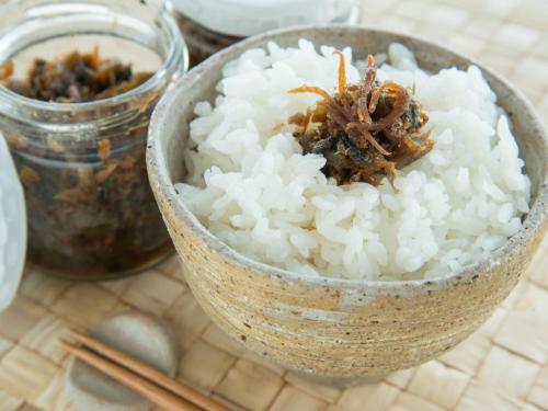 a bowl of rice on a table with chopsticks at Nakaya Ryokan in Kakeyu