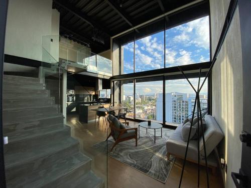 a living room with a couch and a large window at Loft Doble Altura Americana Piso 5 @serra in Guadalajara