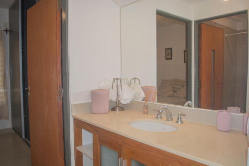 y baño con lavabo y espejo. en Deptos Bajo la Viña en San Salvador de Jujuy