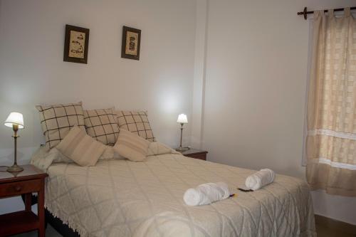 1 dormitorio con 1 cama con 2 toallas en Deptos Bajo la Viña en San Salvador de Jujuy
