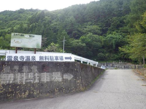 a sign on a wall next to a mountain at Nakaya Ryokan in Kakeyu