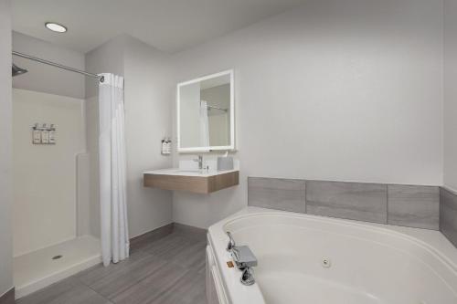 a white bathroom with a tub and a sink at Holiday Inn Express & Suites Superior by IHG in Superior