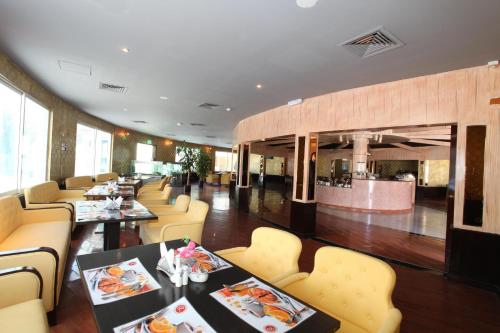 a dining room with tables and chairs and a restaurant at Ramee Dream Resort in Seeb