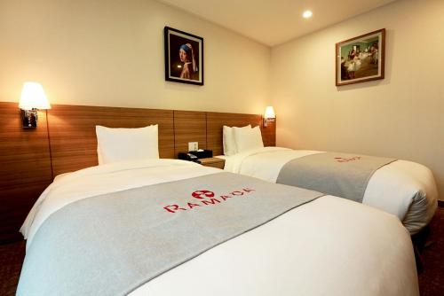 una camera d'albergo con due letti con un cartello della farmacia di Ramada Taebaek Hotel a Taebaek