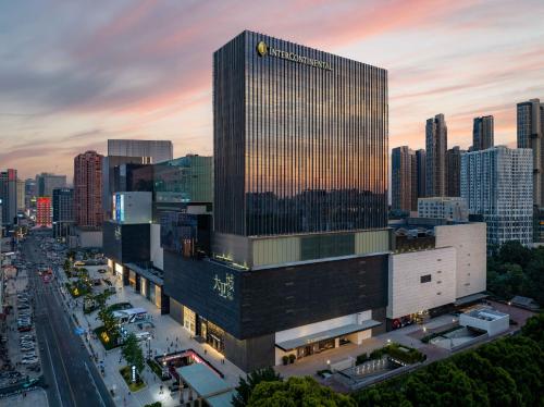 a tall building with a clock on it in a city at InterContinental Hotels Zhengzhou in Zhengzhou