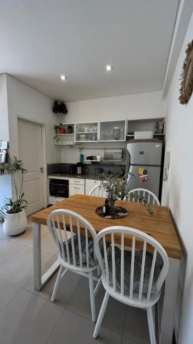 a kitchen with a wooden table and two chairs at Departamento TANGO - Céntrico - Balcón - Zona Cardiológico in Corrientes