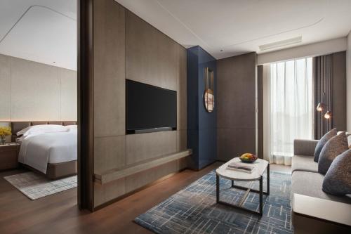 a hotel room with a bed and a television at InterContinental Hotels Zhengzhou in Zhengzhou