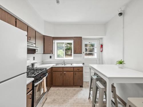 a kitchen with wooden cabinets and a white counter top at Oakland/University @B Quiet & Stylish Private Bedroom with Shared Bathroom in Pittsburgh