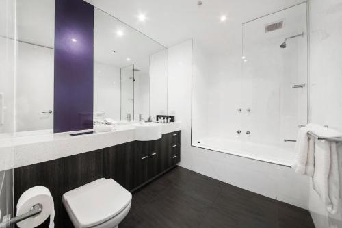 y baño con aseo, lavabo y ducha. en Tyrian Serviced Apartments Fitzroy, en Melbourne