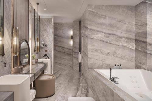 a bathroom with a tub and a sink at InterContinental Hotels Zhengzhou in Zhengzhou