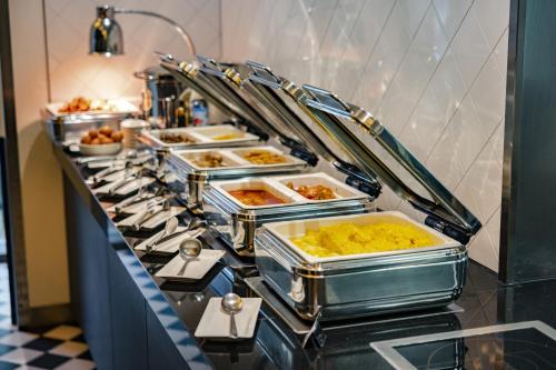 a buffet line with many trays of food at Crowne Plaza Amsterdam - South by IHG in Amsterdam