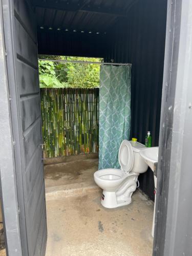 y baño con aseo y lavamanos. en Ricks hostel, en Juayúa