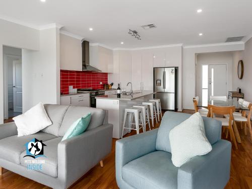 a living room with two couches and a kitchen at 4BR Contemporary Coastal Home with Rural Outlook in Port Elliot