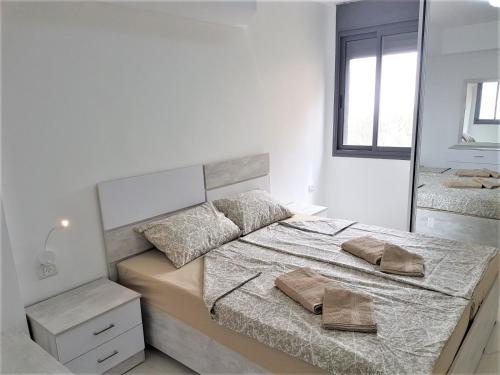 Habitación blanca con cama y espejo en 4bdrm - 110mr - Dream vacation apartment en Tiberias