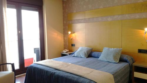 a bedroom with a bed and a large window at Isla Nova Hotel in Foz