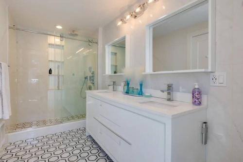 a white bathroom with a sink and a shower at Cape Cod Home w/Ocean View, Roof Top, Pool & Hot Tub in Wellfleet