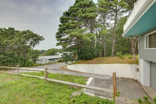 a house with a fence next to a driveway at Cape Cod Home w/Ocean View, Roof Top, Pool & Hot Tub in Wellfleet