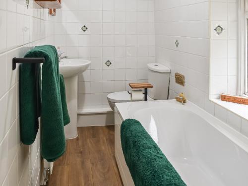 a bathroom with a tub and a sink and a toilet at Ty Tarth in Pen-y-groes