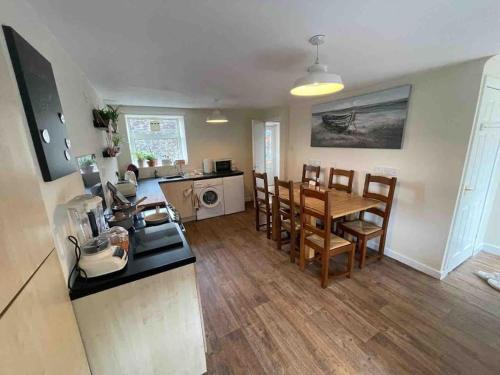 cocina y comedor con mesa y sillas en Honeycomb Cottage, en Newburgh