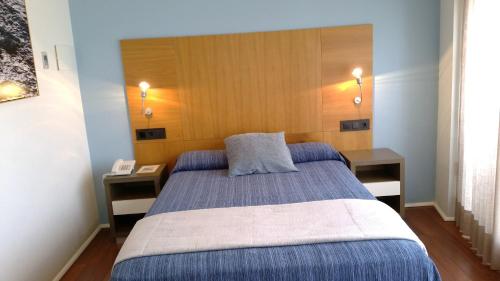 a bedroom with a bed with two nightstands and sidx sidx sidx at Isla Nova Hotel in Foz