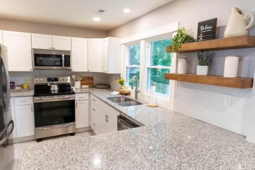 a kitchen with white cabinets and a stove top oven at Parker House - 15 mins to Downtown Asheville in Fairview