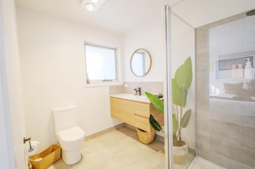 a bathroom with a toilet and a sink and a shower at Cozy Home Close to Beach and Hobart CBD in Hobart