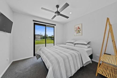 Un dormitorio con una cama y un ventilador de techo. en The Red Door, en Martinborough