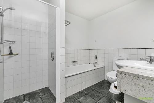 a bathroom with a tub and a toilet and a sink at QV Private City Hub Apartment - 484 in Auckland