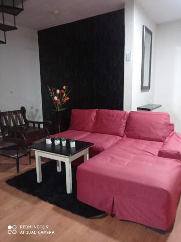 een woonkamer met een rode bank en een tafel bij Mardry in Trujillo