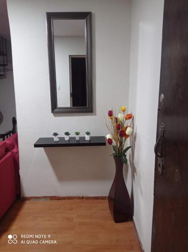 een badkamer met een vaas met bloemen en een spiegel bij Mardry in Trujillo