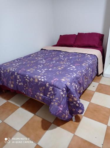 een bed met een paars dekbed op de bovenste verdieping bij Mardry in Trujillo
