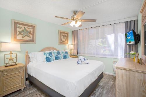 ワイレアにあるRemodeled 1BR 2BA at Kamaole Sands - Steps to Beach!のベッドと天井扇風機のある寝室