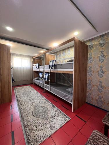 a room with bunk beds and a red tile floor at InJoy in Shymkent