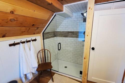 a bathroom with a shower with a chair in it at Sequoia Glen in Wilsonia
