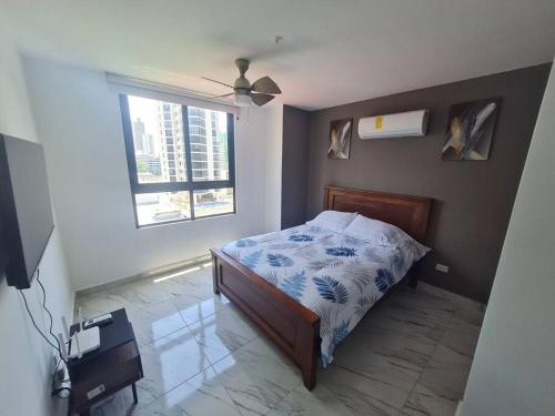 um quarto com uma cama e uma janela em Espectacular apartamento en calle 50 na Cidade do Panamá