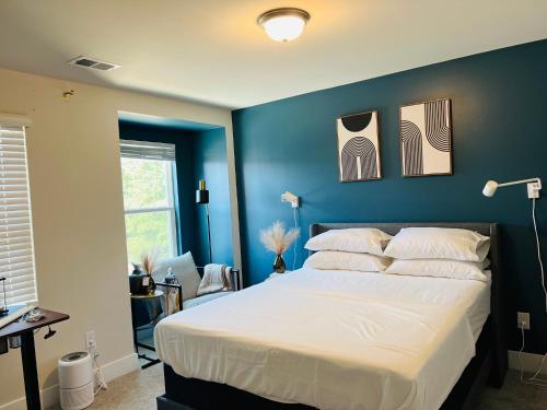a bedroom with a large bed with blue walls at Charlotte Comfort Haven in Charlotte