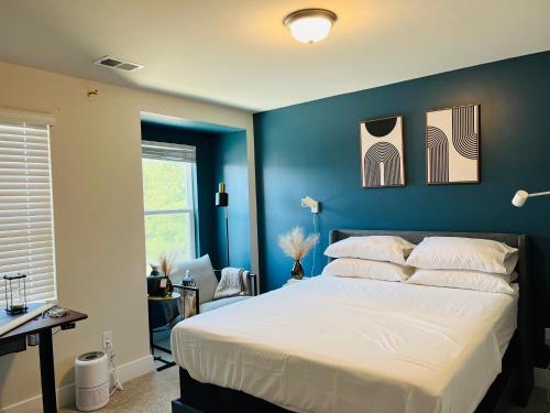 een slaapkamer met een groot bed met blauwe muren bij Charlotte Comfort Haven in Charlotte