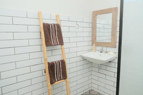 a bathroom with a towel rack and a sink at Hideaway Batukaras in Pangandaran