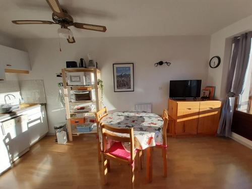 une chambre avec une table et une cuisine avec un ventilateur de plafond dans l'établissement Studio cabine avec balcon et parking à Villard-de-Lans - FR-1-515-177, à Villard-de-Lans