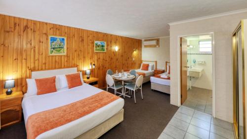 a hotel room with a bed and a bathroom at Blue Diamond Motor Inn in Dubbo